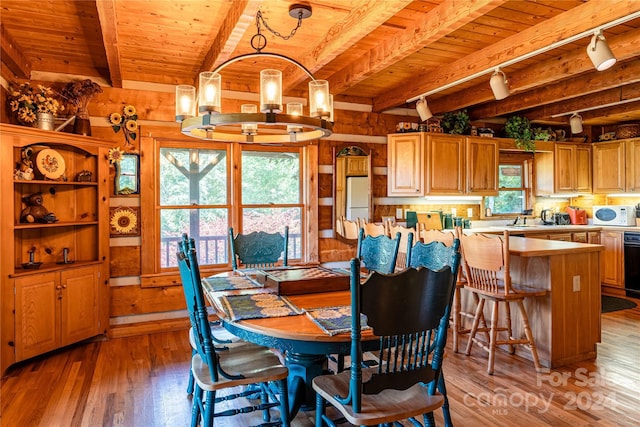 dining room featuring light wood-style floors, wood ceiling, a notable chandelier, and beamed ceiling