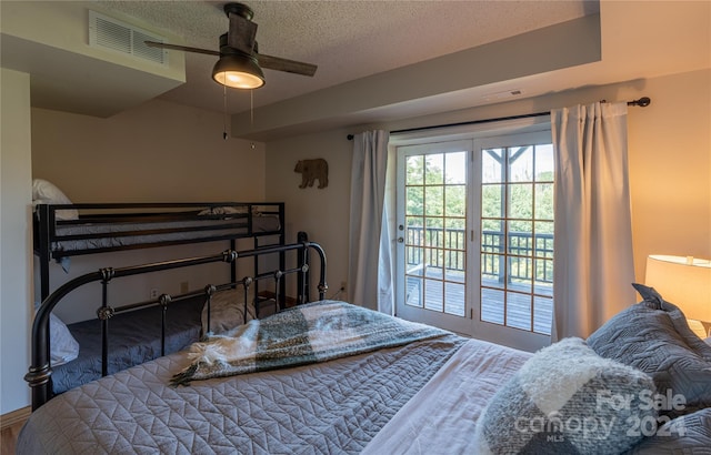 bedroom with access to outside, visible vents, ceiling fan, and a textured ceiling