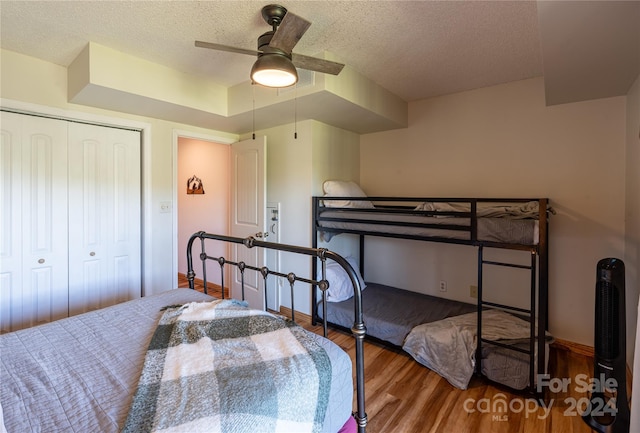 bedroom with visible vents, baseboards, a ceiling fan, wood finished floors, and a textured ceiling