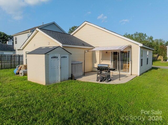 rear view of house featuring a patio area, a yard, and a storage shed