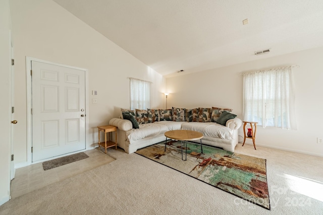 living room with light colored carpet and high vaulted ceiling