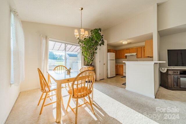 dining area featuring light carpet, an inviting chandelier, and lofted ceiling