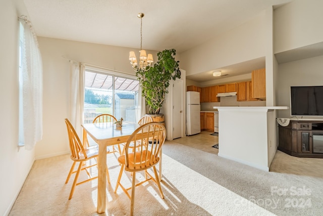 dining area with a notable chandelier, vaulted ceiling, baseboards, and light colored carpet