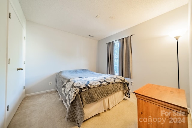 carpeted bedroom featuring a textured ceiling