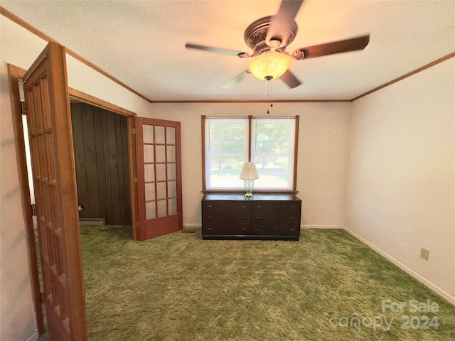 unfurnished bedroom with a textured ceiling, ornamental molding, carpet, and baseboards