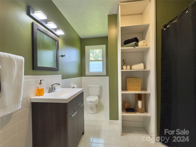 bathroom featuring built in features, toilet, a textured ceiling, vanity, and tile patterned floors