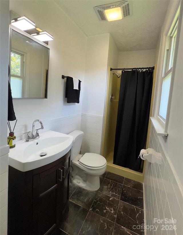 bathroom with visible vents, toilet, a shower stall, and vanity