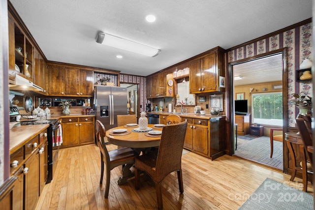 kitchen with appliances with stainless steel finishes, sink, light hardwood / wood-style flooring, and ornamental molding