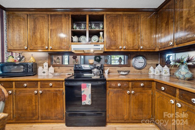 kitchen with light hardwood / wood-style floors and black appliances