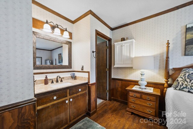 bathroom featuring hardwood / wood-style flooring, ornamental molding, and vanity