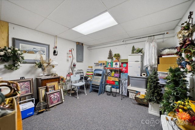 interior space featuring a drop ceiling, carpet floors, and electric panel