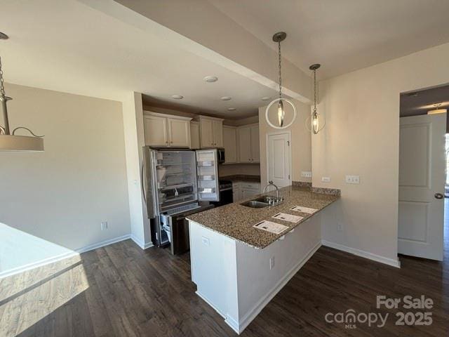 kitchen with a peninsula, dark wood-style flooring, white cabinets, and a sink