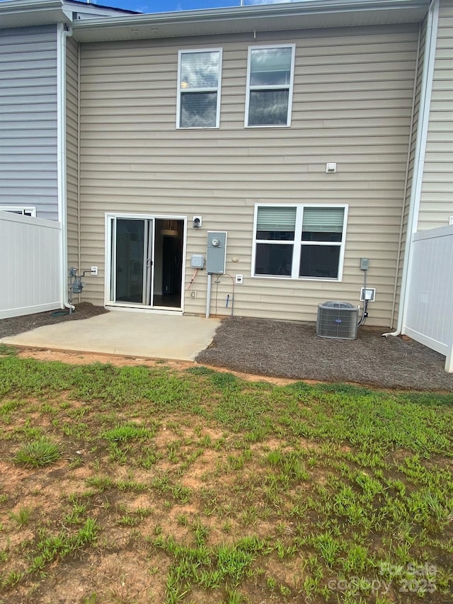 back of property featuring cooling unit, a patio, a lawn, and fence