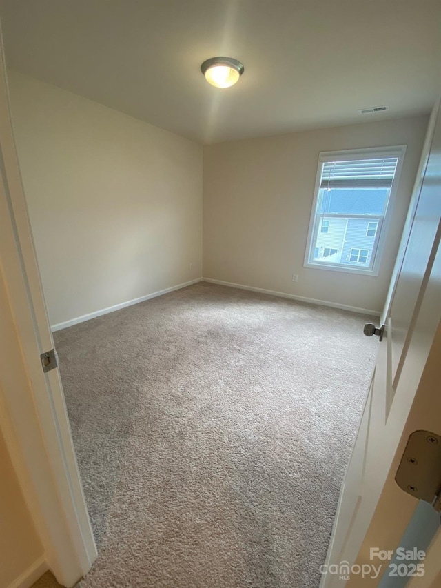 unfurnished room with carpet flooring, visible vents, and baseboards