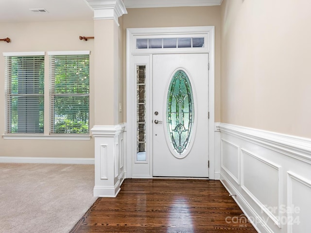 entrance foyer with crown molding, decorative columns, and dark hardwood / wood-style flooring