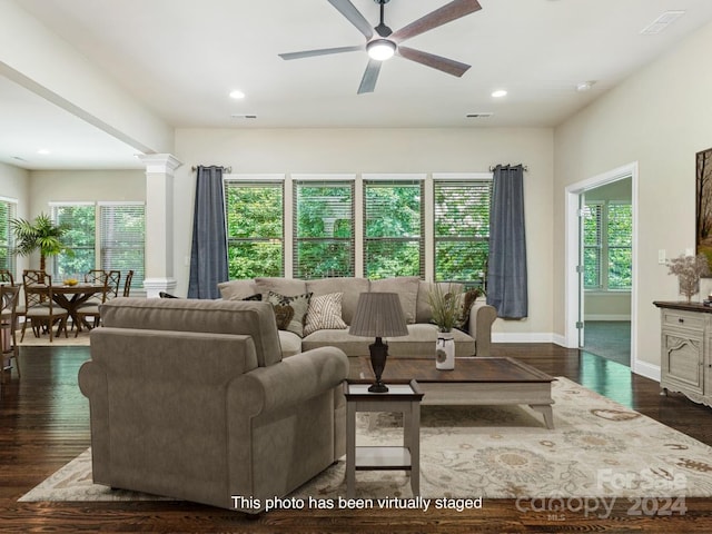 living room featuring ceiling fan, dark hardwood / wood-style flooring, and decorative columns