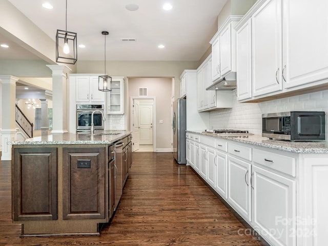 kitchen featuring stainless steel appliances, white cabinetry, tasteful backsplash, ornate columns, and dark hardwood / wood-style flooring