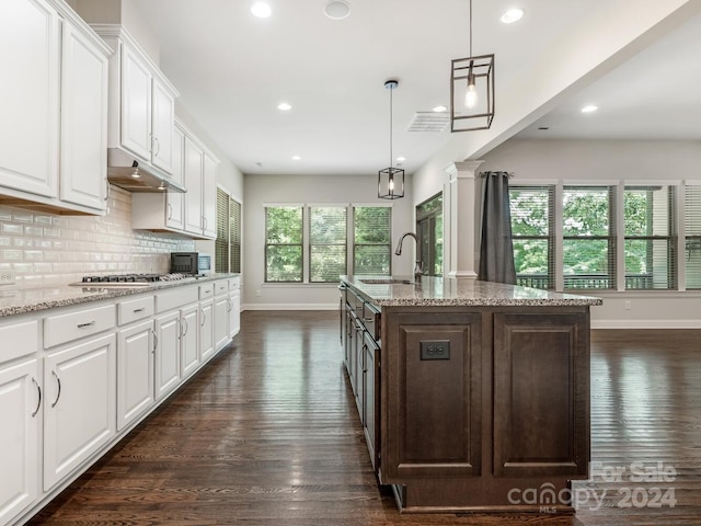 kitchen with dark hardwood / wood-style flooring, tasteful backsplash, white cabinetry, light stone countertops, and sink