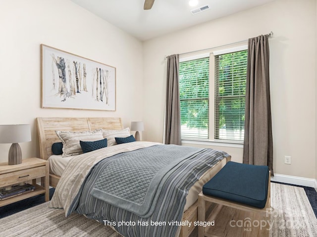 bedroom featuring ceiling fan, hardwood / wood-style floors, and multiple windows