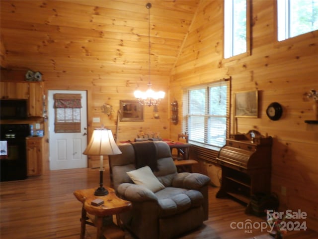 living room featuring wood walls, a notable chandelier, and wood-type flooring