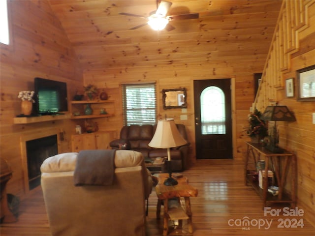 living room featuring wood walls, ceiling fan, wood-type flooring, and wood ceiling