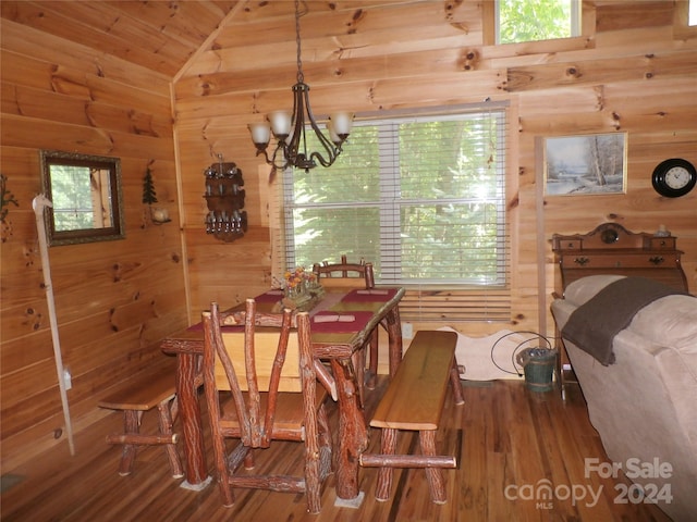 dining space featuring a notable chandelier, vaulted ceiling, wood walls, and wood-type flooring