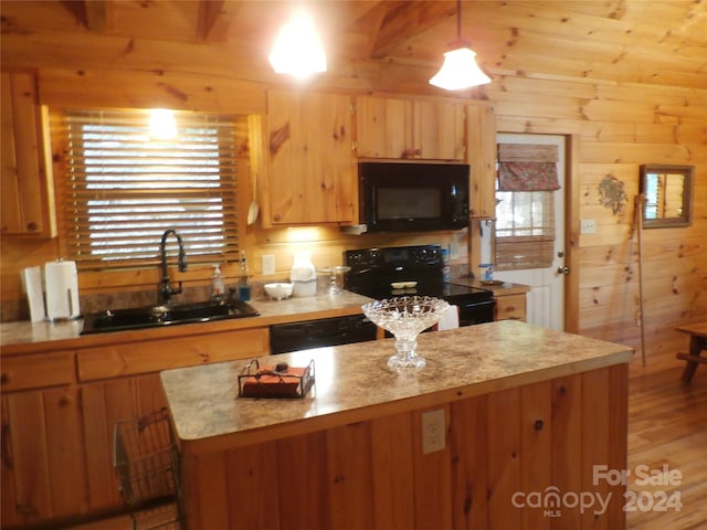 kitchen with black appliances, wood walls, light hardwood / wood-style floors, sink, and beamed ceiling