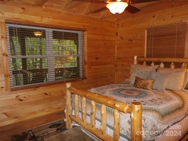 bedroom with ceiling fan and wooden walls