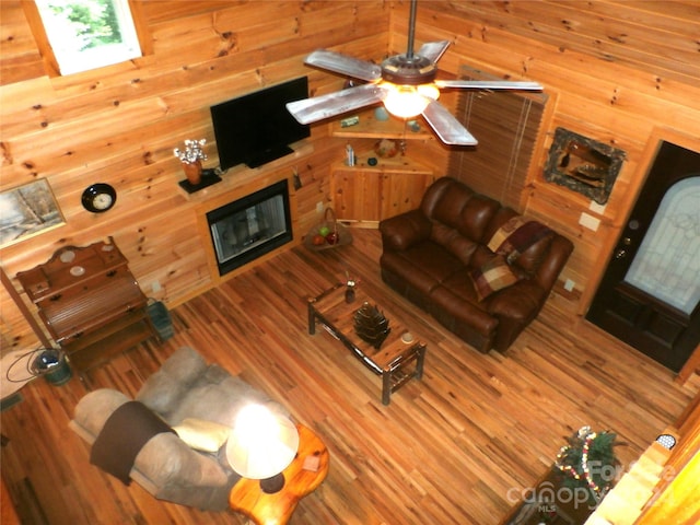 living room with wood walls and wood-type flooring