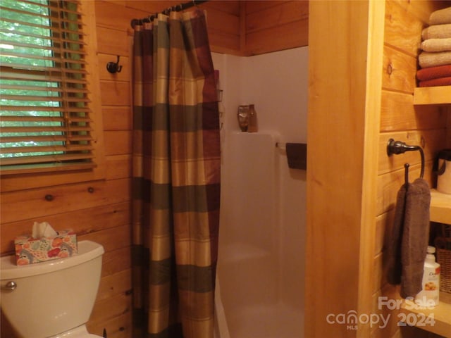 bathroom featuring wood walls and toilet