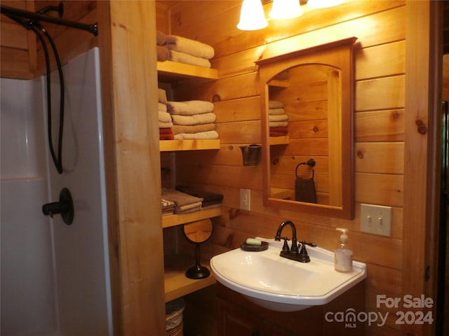 bathroom with wood walls and vanity