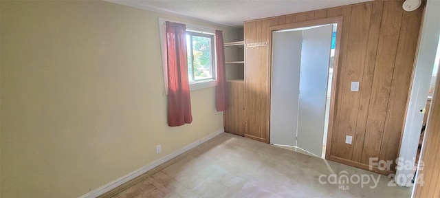 unfurnished bedroom featuring a textured ceiling and baseboards