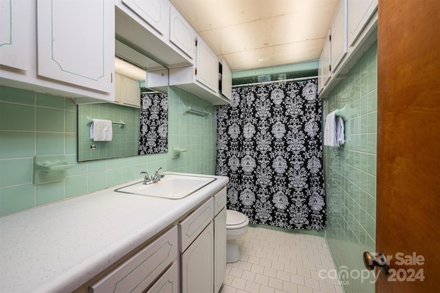 full bath with tile walls, toilet, vanity, a shower with curtain, and tile patterned floors