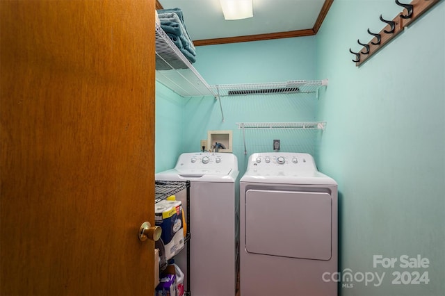 clothes washing area featuring washer and dryer, laundry area, and crown molding