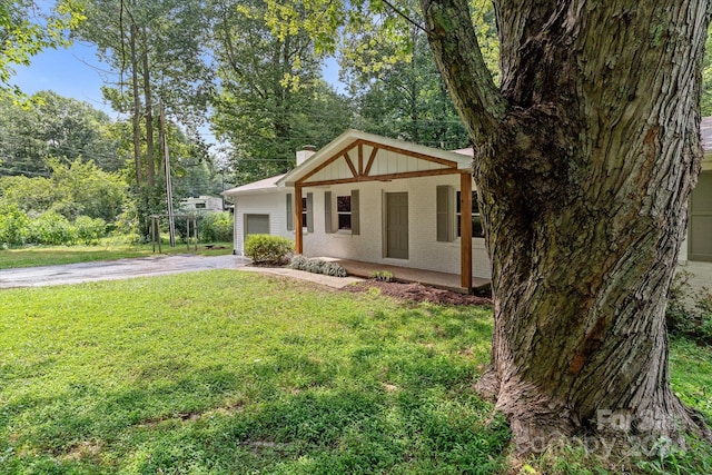 view of front of home featuring covered porch, a garage, and a front yard