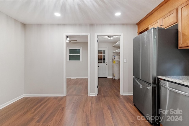 kitchen featuring ceiling fan, stainless steel dishwasher, hardwood / wood-style flooring, and light brown cabinets