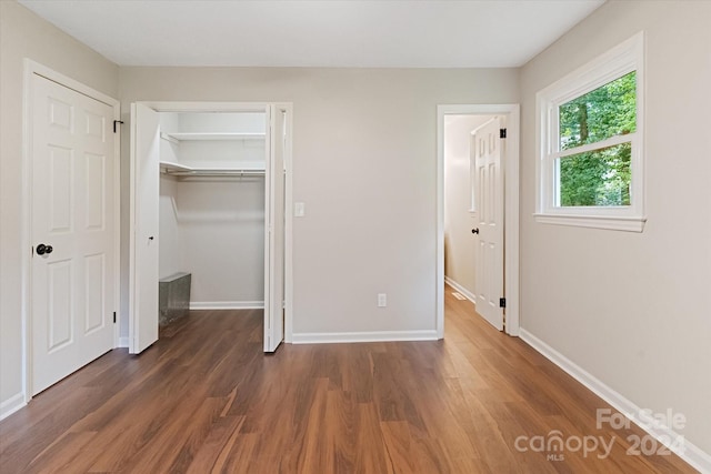 unfurnished bedroom with a closet and wood-type flooring