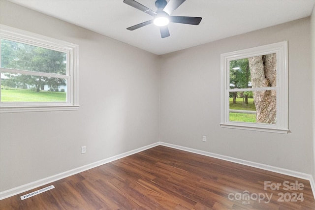 unfurnished room with hardwood / wood-style flooring, a healthy amount of sunlight, and ceiling fan