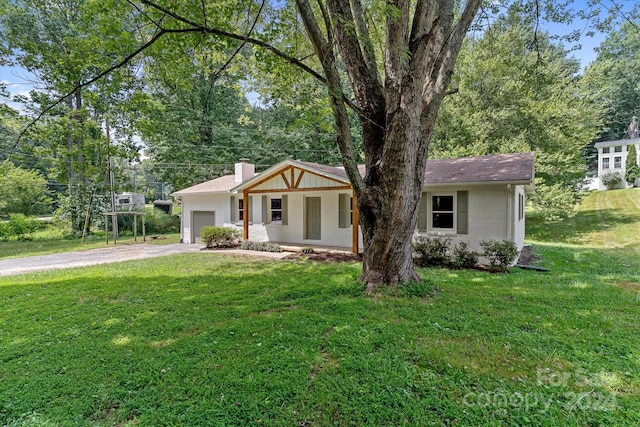 ranch-style house with a garage and a front lawn