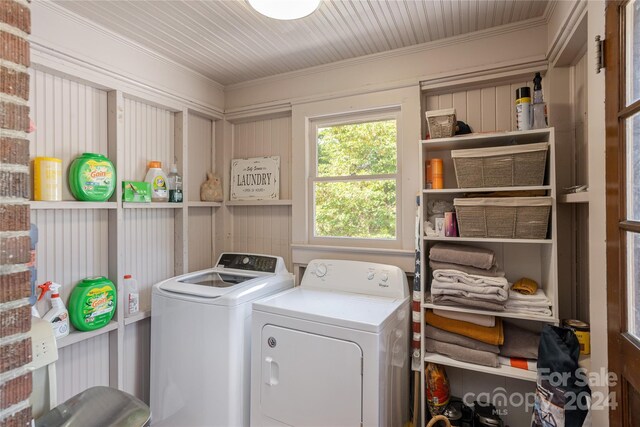 clothes washing area featuring washing machine and clothes dryer and ornamental molding