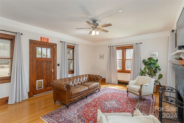 living room featuring crown molding, ceiling fan, and wood-type flooring