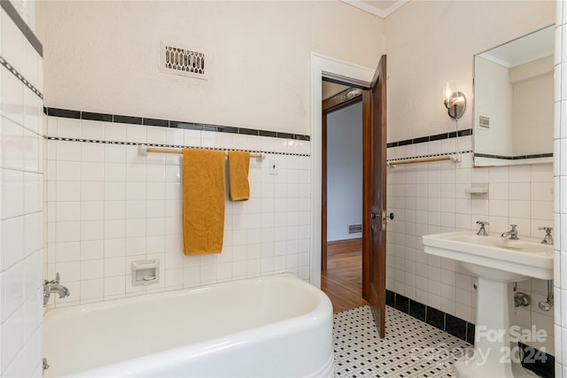 bathroom with a bath, tile walls, and tile patterned floors