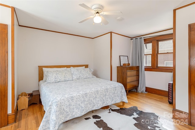 bedroom with light hardwood / wood-style flooring, ceiling fan, and ornamental molding