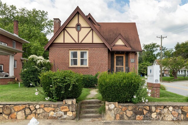 english style home with a front lawn