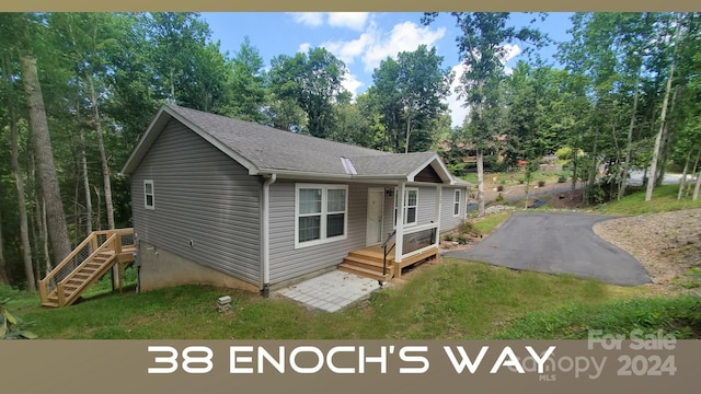 38 Enochs Way, Fletcher, NC 28732 - view of front of house with a shingled roof, view of wooded area, and a front lawn