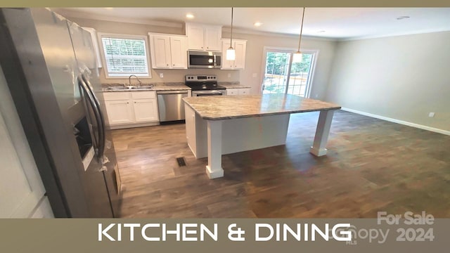 kitchen with pendant lighting, a center island, white cabinets, and stainless steel appliances