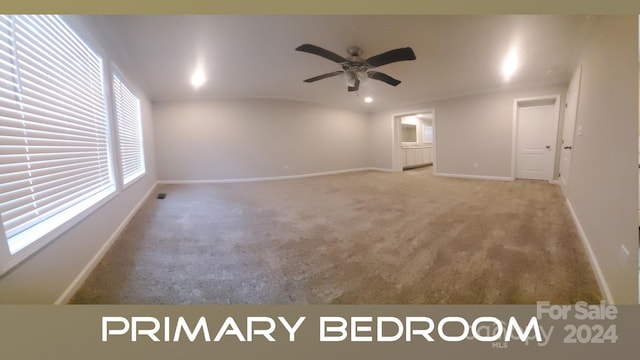 unfurnished room with carpet flooring, vaulted ceiling, and ceiling fan