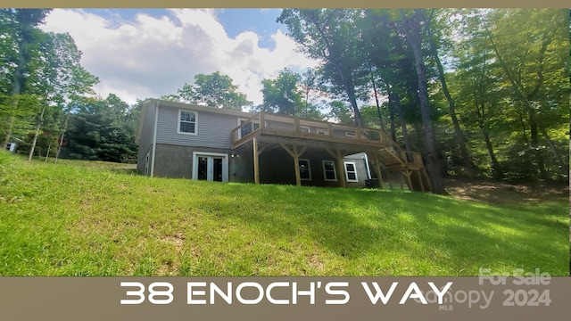 back of house featuring a lawn and a wooden deck