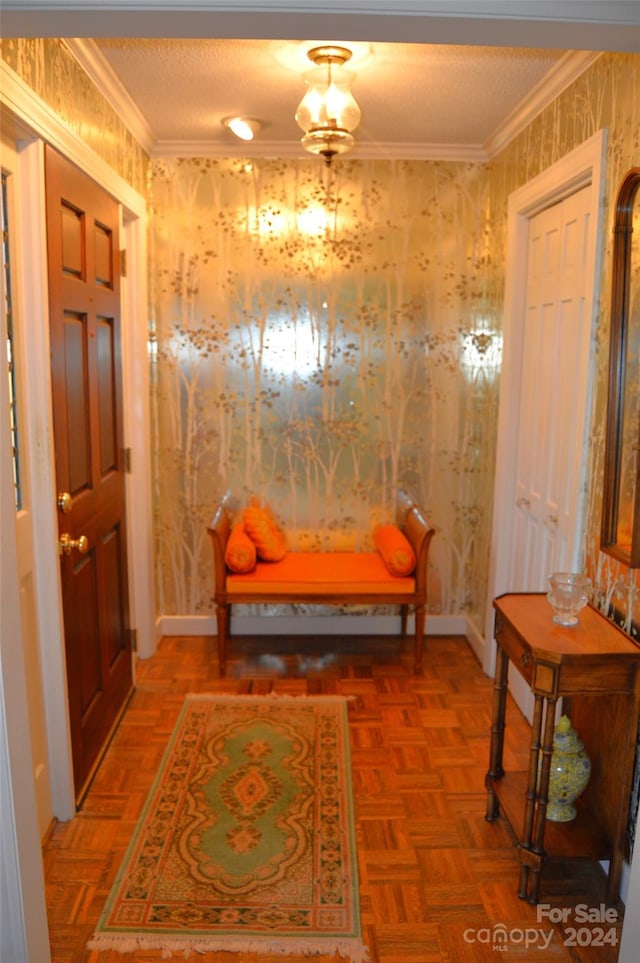 foyer featuring parquet flooring, ornamental molding, and a textured ceiling