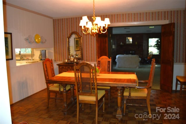 dining area featuring an inviting chandelier, dark parquet flooring, and ornamental molding